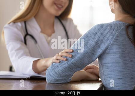 Fürsorglicher weiblicher Arzt tröstet junge Frau Patient bei der Sitzung Stockfoto