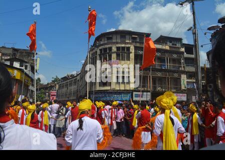 Pune, Indien - 4. September 2017: Dhol tasha pathak tanzt mit drei orangefarbenen Fahnen und feiert das Ganapati visarjan Festival. Dhol tasha pathak auf der Straße Stockfoto