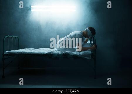 Psycho Mann mit verbundenen Augen im Bett sitzen, Krankenhaus Stockfoto