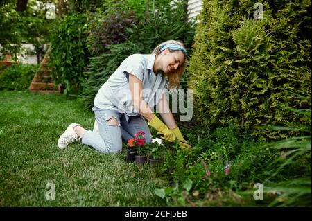 Frau mit Hacke wächst Blumen im Garten Stockfoto