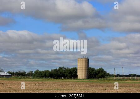 Kansas Farmsilo mit blauem Himmel und weißen Wolken auf dem Land. Stockfoto