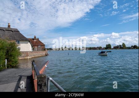 Bosham Village in West Sussex bei Flut mit Wasser über die Straße vor dem Dorf an dieser schönen Lage. Stockfoto