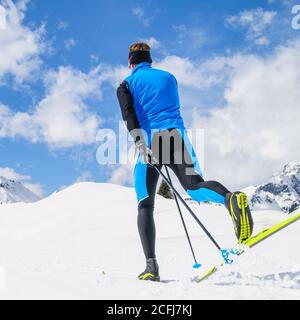 Sportlicher Mann bei einer Tour auf Langlaufskiern in klassischer Musik Stil Stockfoto