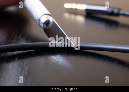 Schneiden Sie dicken Draht mit einem technischen Skalpell Stockfoto