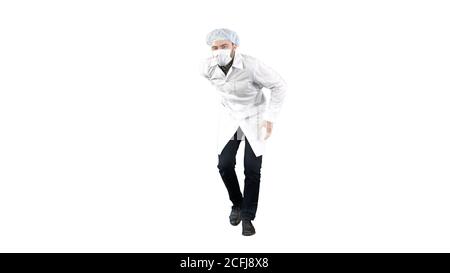 Doktor trägt seine Uniform und trägt eine Maske, er geht auf lustige Weise auf weißem Hintergrund. Stockfoto