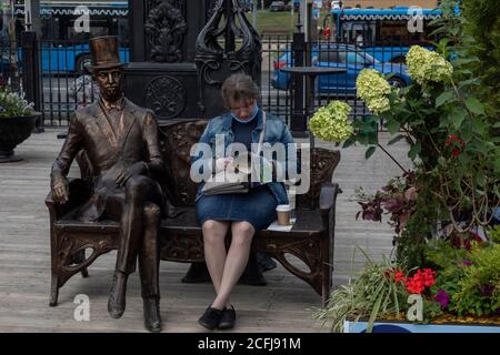 Moskau, Russland. 5. September 2020 EINE Frau sitzt auf einer Bank und liest eine Zeitung auf dem Orekhovy Boulevard in Moskau, Russland Stockfoto