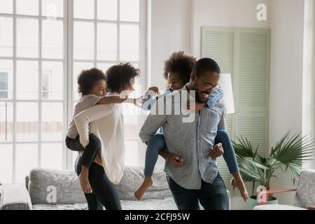 Glückliche afroamerikanische Familie spielen aufholen zu Hause.