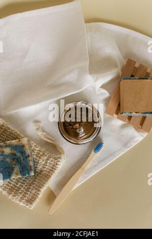 Öko Zahnbürste aus Holz, natürliche Seife und Vorbereitung Bio-Gesichtsmaske auf weißem Handtuch zu Hause. Stockfoto
