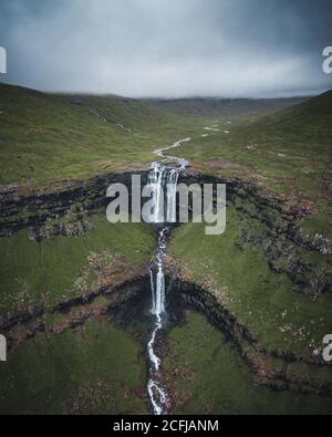 Luftaufnahme des Fossa Wasserfalls von direkt oben, dem höchsten Wasserfall der Färöer Inseln. Dieser zweistufige Wasserfall ist 459 Meter hoch und Stockfoto