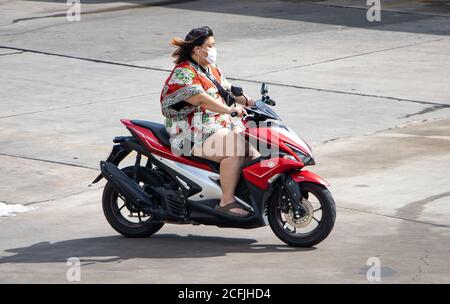 SAMUT PRAKAN, THAILAND, JUNI 26 2020, EINE Frau mit Gesichtsmaske fährt ein Motorrad. Stockfoto