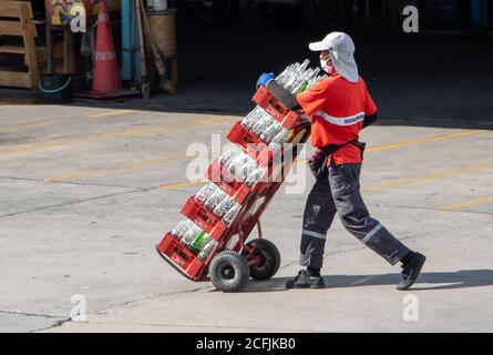 SAMUT PRAKAN, THAILAND, JUL 23 2020, Arbeiter Rollwagen voll von einer Kiste mit leeren Flaschen. Die Getränkelieferung zu Restaurants und Geschäften. Stockfoto