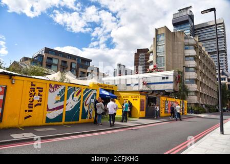 London, Großbritannien. September 2020. Die Leute stehen an Essig Yard Street Food, Bar und Markt in Fenning Street, wo eine Skulptur von riesigen Ameisen kriecht über einen Zug Wagen von Joe Rush und die Mutoid Waste Co. Die riesigen Ameisen Skulpturen sind aus umfunktionierten Materialien, Ihre Körper und Köpfe sind aus Motorrad-Kraftstofftanks. Kredit: SOPA Images Limited/Alamy Live Nachrichten Stockfoto