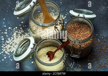 Cerealien (Haferflocken, Buchweizen, Reis) in Gläsern in der Küche. Glutenfreies Konzept. Sorten von Getreide für die Herstellung von gesunden hausgemachten Speisen und Mahlzeiten. Stockfoto