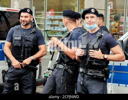 Berlin, 29. August 2020: Junge deutsche Polizeibeamte warten lachend und entspannt am Rande einer Demonstration gegen die Corona-Beschränkung Stockfoto