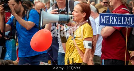 Berlin, 29. August 2020: Frau mittleren Alters mit roten Haaren spricht während der Demonstration gegen Coronaeinschränkung durch ein Megaphon Stockfoto