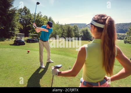 Golf spielen Frau und Mann am Abschlag Stockfoto