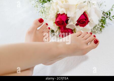 Füße von Frauen mit roten Zehennägeln nach der Pediküre Stockfoto