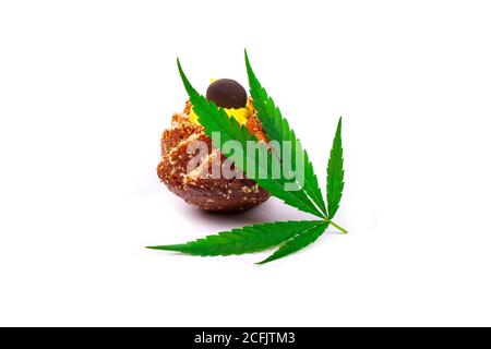 Süßer frischer Cupcake mit grünem Blatt Marihuana-Pflanze isoliert auf weißem Hintergrund, Cannabis Butter Süßigkeiten. Stockfoto