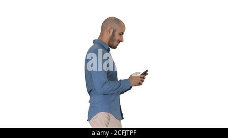 Junger Mann, der läuft und ein Telefon auf weißem Hintergrund benutzt. Stockfoto