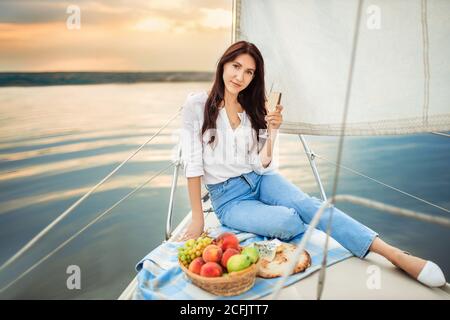 Frau mit einem Glas Champagner auf der Yacht Stockfoto