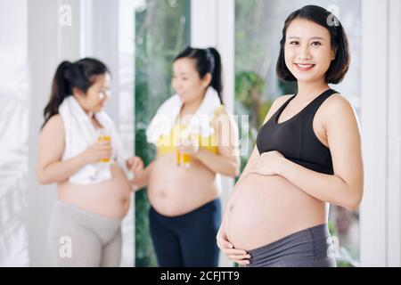 Fröhliche schwangere asiatische Frau Stockfoto