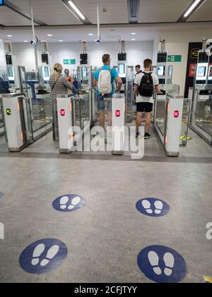 Fluggäste, die die elektronischen Geräte für die Einwanderungs- und Passkontrolle an der britischen Grenze am Flughafen Gatwick verwenden. Stockfoto