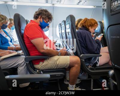 Passagiere mit Gesichtsmaske/-Abdeckung an Bord eines easyJet-Fluges. Stockfoto