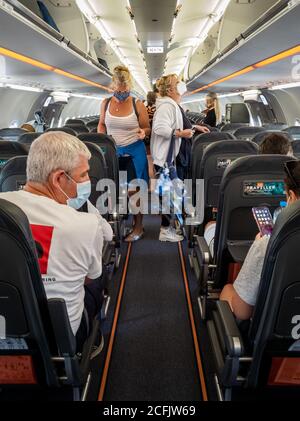 Passagiere mit Gesichtsmaske/-Abdeckung an Bord eines easyJet-Fluges. Stockfoto