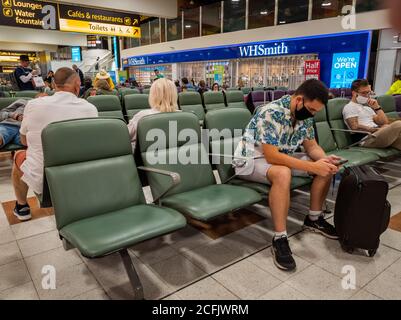 Fluggäste im Nordterminal des Flughafens Gatwick warten auf ihren Flug. Stockfoto