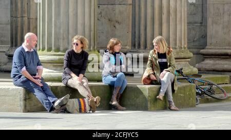 Glasgow, Schottland, UK, 6. September, 2020: UK Wetter: Sonniges Sommerwetter und wahrscheinlich das letzte des Jahres sahen Einheimische und Touristen die Grüns des George Square und die Straßen des Stadtzentrums genießen, während die Stadt in Lockdown weitergeht. Wie die Menschen genießen die Stufen vor der Galerie der modernen Kunst oder GOMA. Quelle: Gerard Ferry/Alamy Live News Stockfoto