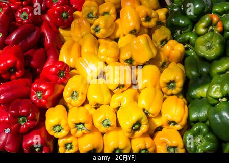 Rote, gelbe und grüne Paprika zum Verkauf auf einem Outdoor-Lebensmittelmarkt Stockfoto