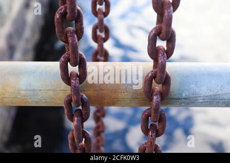 Rostige Kette um Metallstangen im Hafen von Kiel Stockfoto
