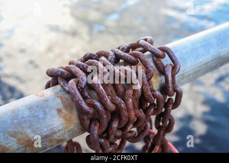 Rostige Kette um Metallstangen im Hafen von Kiel Stockfoto