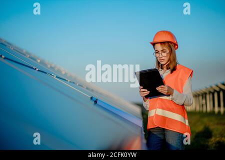 Inspector Engineer Frau hält digitale Tablette Arbeiten in Solarzellen Kraftwerk, Photovoltaik-Zellpark, Green Energy Konzept Stockfoto