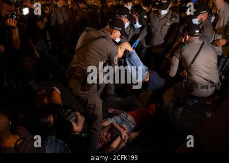 JERUSALEM, ISRAEL - SEPTEMBER 05: Die Polizei entfernt Demonstranten, die eine Straße blockieren, während einer Demonstration, an der über 15000 Personen im Rahmen der laufenden Demonstrationen gegen Premierminister Benjamin Netanjahu wegen seiner Anklage wegen Korruptionsvorwürfen und des Umgangs mit der Coronavirus-Pandemie in der Nähe des offiziellen Wohnsitzes des Premierministers am 05. September 2020 in Jerusalem, Israel, teilnahmen. Stockfoto