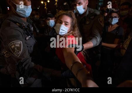 JERUSALEM, ISRAEL - SEPTEMBER 05: Die Polizei entfernt Demonstranten, die eine Straße blockieren, während einer Demonstration, an der über 15000 Personen im Rahmen der laufenden Demonstrationen gegen Premierminister Benjamin Netanjahu wegen seiner Anklage wegen Korruptionsvorwürfen und des Umgangs mit der Coronavirus-Pandemie in der Nähe des offiziellen Wohnsitzes des Premierministers am 05. September 2020 in Jerusalem, Israel, teilnahmen. Stockfoto