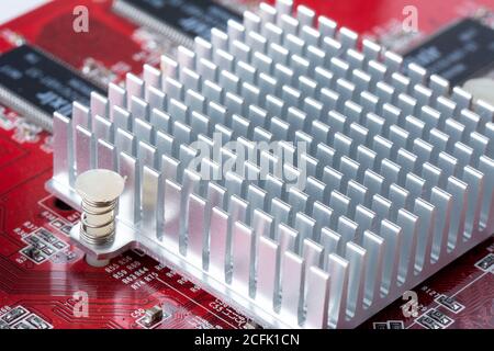 Zerlegte Grafikkarte, Aluminiumkühler auf Wärmeleitpaste. Elektronikkomponenten auf modernem PC-Computer-Mainboard. Stockfoto