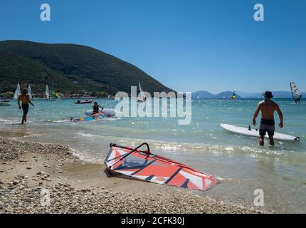 Touristen genießen den Sport zum Windsurfen in den flachen Gewässern der Bucht Vasiliki. Stockfoto