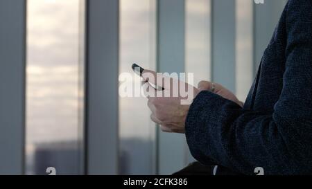 Die Hände des Mannes mit dem modernen Smartphone. Stockfoto