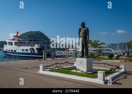 Die Bronzestatue von Aristoteles Onassis in Nydri, dem wohl berühmtesten griechischen Tycoon, der die nahe gelegene Insel Scorpios besitzt. Stockfoto