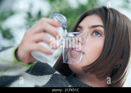 Teenager mit einem Inhalator im Wohnzimmer Stockfoto
