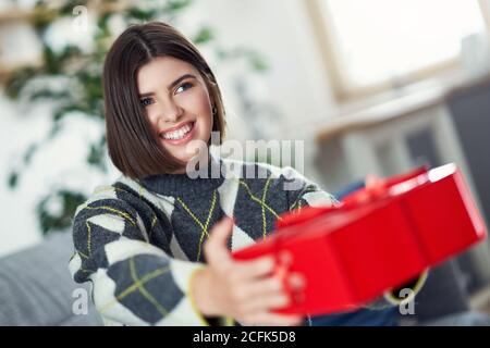 Bild zeigt Frau mit Geschenk zu Hause Stockfoto