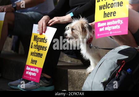 Demonstranten, die mit einem Hund auf der Buchanan Street Steps in Glasgow sitzen, nehmen an einer Protestkundgebung für Flüchtlinge und Black Lives Matter Teil, die von Stand Up to Racism Scotland organisiert wird. Stockfoto