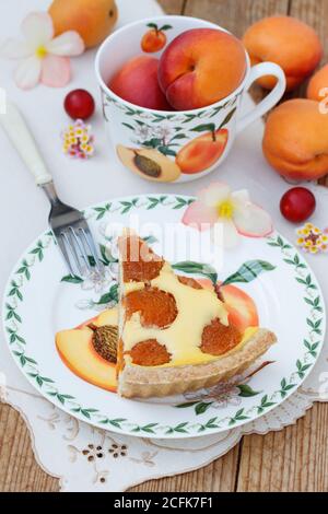 Aprikosen-Tarte auf dem Teller und frische Aprikosen in der becher Stockfoto