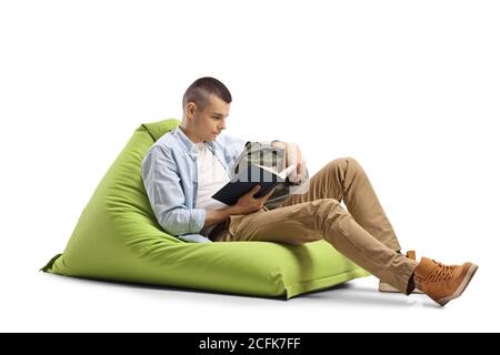 Kerl auf einem grünen Sitzsack Stuhl sitzen und lesen Ein Buch isoliert auf weißem Hintergrund Stockfoto