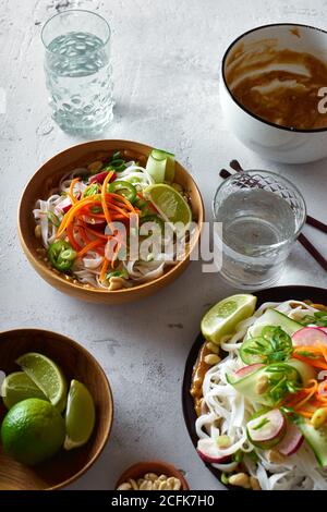 Veganer Reisnudelsalat mit frischem Gemüse, Limette und Erdnusssoße Stockfoto