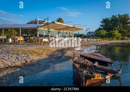 Ein Fischrestaurant im Fischerdorf Lygia, Insel Lefkada, Griechenland, bietet Gästen Abendessen am Strand. Stockfoto