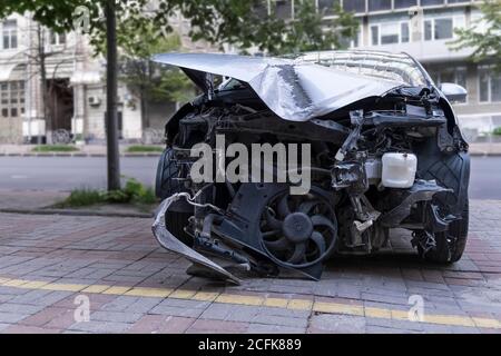 Car Crush. Nahaufnahme eines zerstörten Autos. Auto nach Frontalaufprall. Verbogene Haube und gebrochene Teile Stockfoto