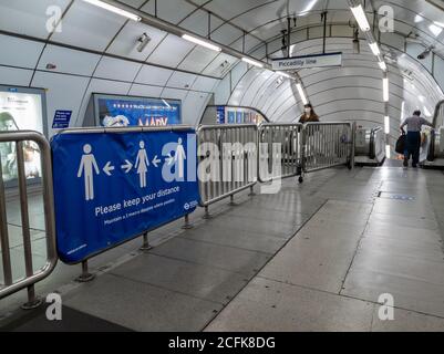 Ein soziales Distanzierungsbanner auf dem Geländer in der Holborn London Underground, das den Passagieren aufzeigt, zwei Meter voneinander entfernt zu bleiben. Stockfoto