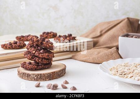 Stillleben von einem Stapel frisch gebackener Backöfen Haferflocken und Bananenschokolade-Chips über einer Holzrüsselscheibe Stockfoto